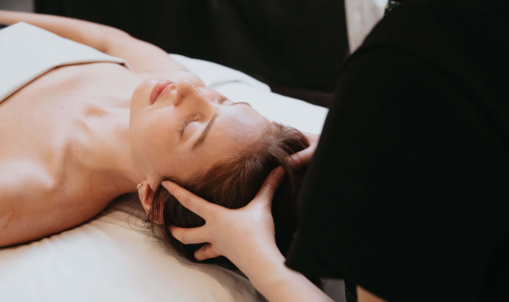A young caucasian woman receiving a head massage