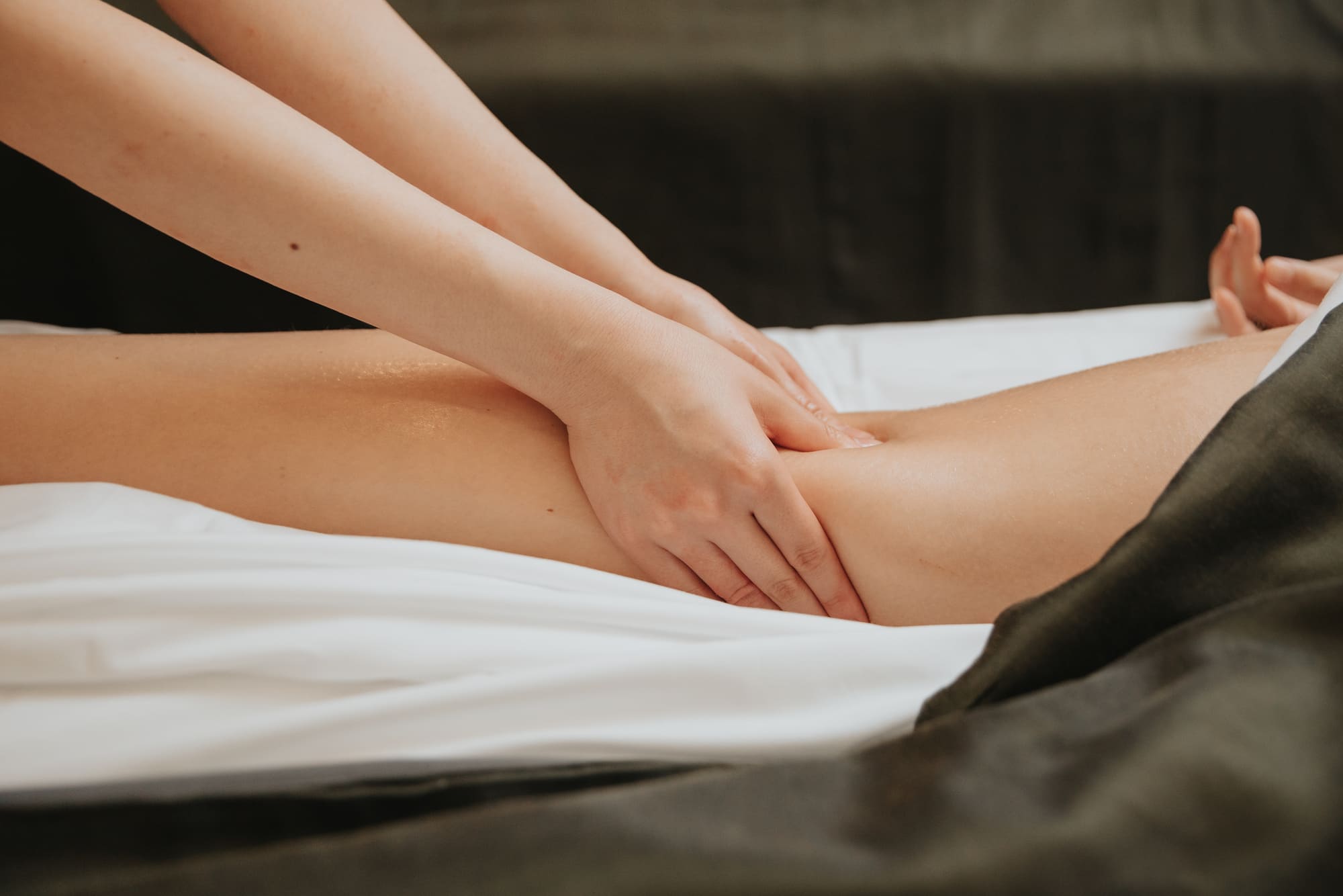 A pair of hands massaging a woman's leg