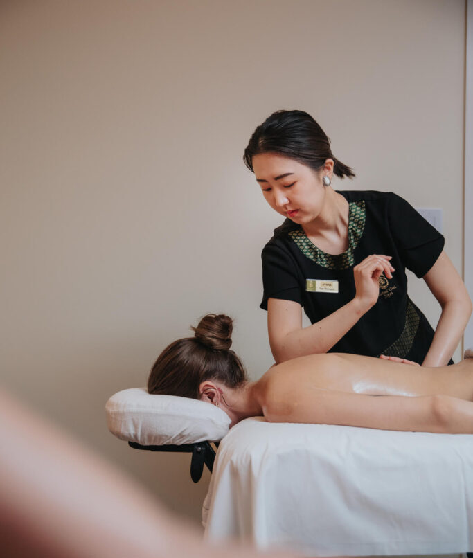 a professional masseuse giving a woman a back massage at Sabai Thai