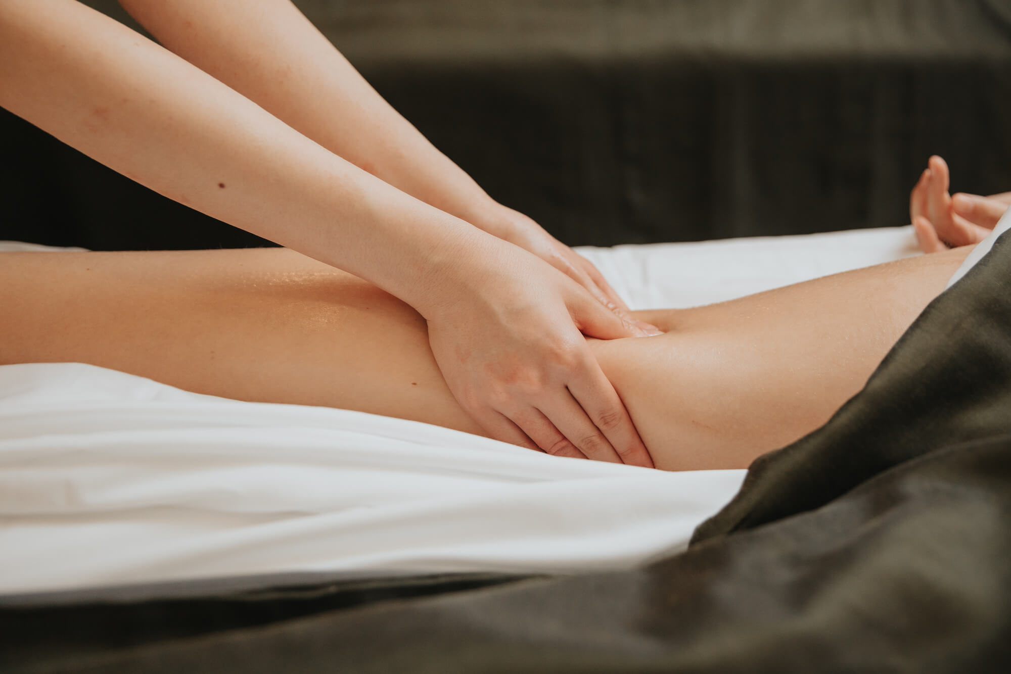 Massage therapist massaging a woman's calf