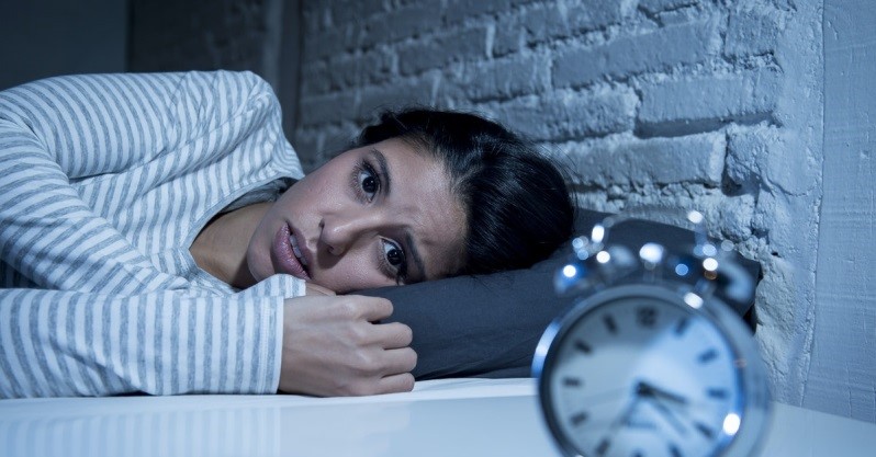 Girl who can't sleep looking at clock