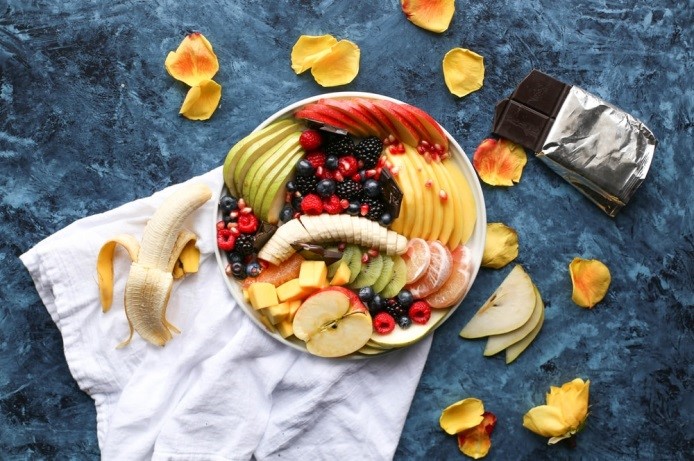 Platter fruits and berries. Mango, kiwi, fig, strawberry, grapes, pear and orange. Vegan cuisine. Dietary menu. Flat lay. Top view